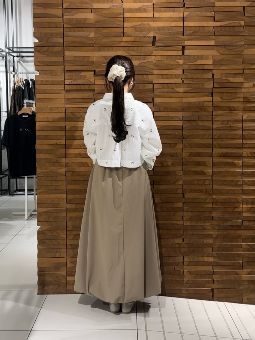 ベージュ系のスカート、ベージュ系のハンドバッグ、ホワイト系のシャツ/ブラウスを着用したレディースの春コーディネートの3枚目の写真