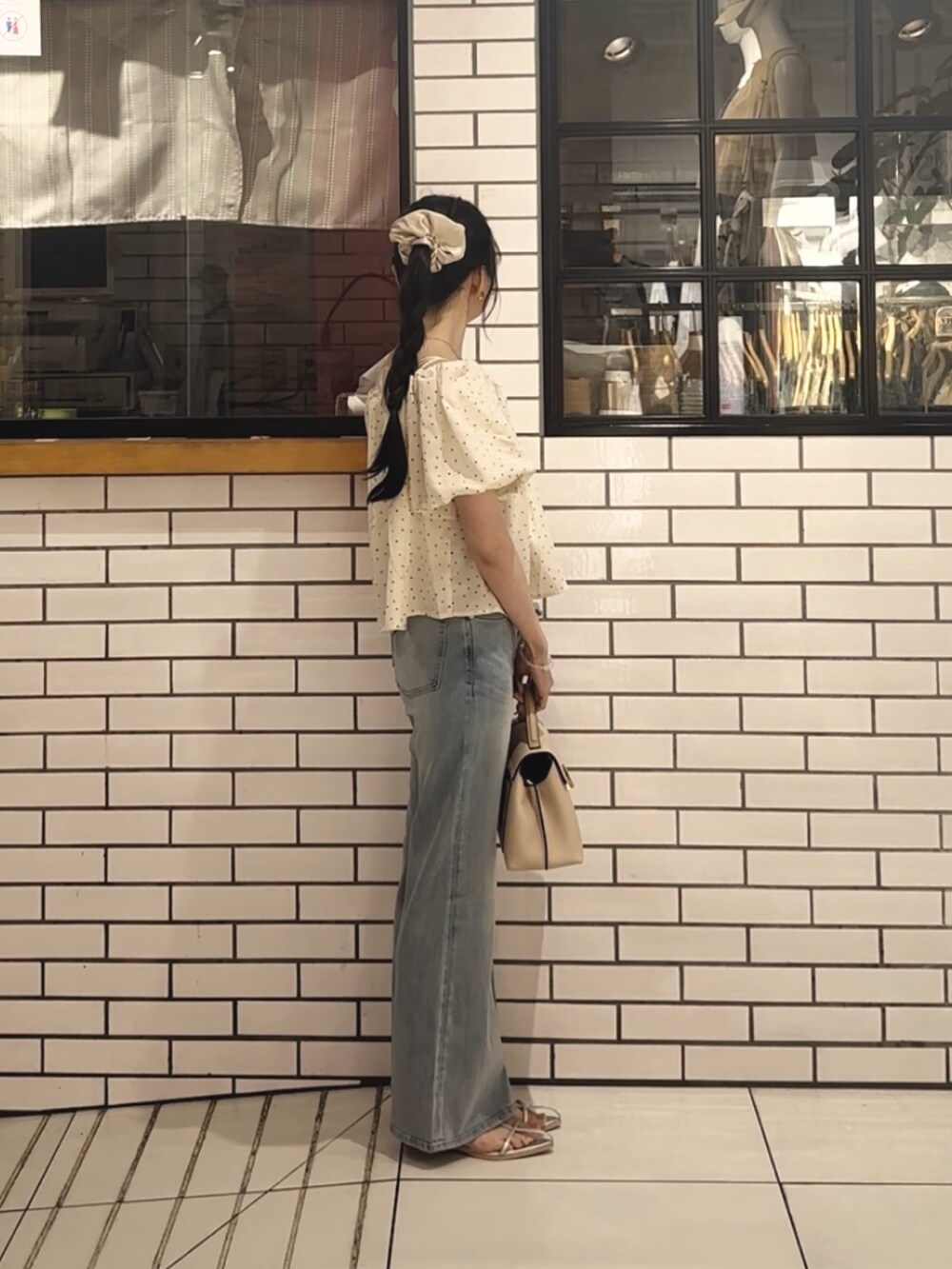 ホワイト系のシャツ/ブラウス、ブルー系のデニムパンツ、ホワイト系のハンドバッグを着用したレディースの夏コーディネートの2枚目の写真