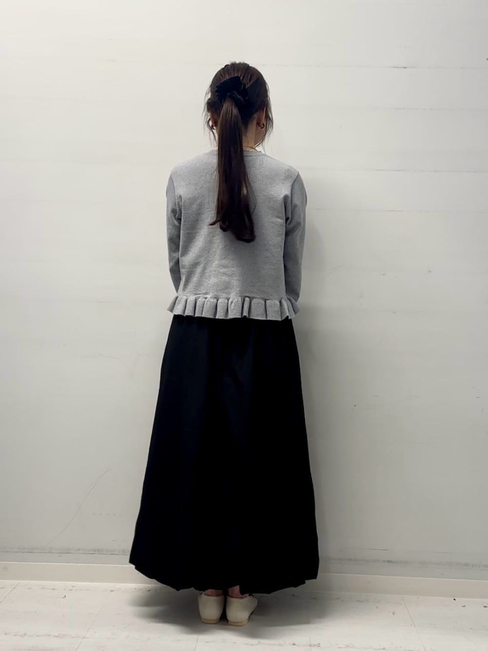 グレー系のニット/セーター、ブラック系のスカートを着用したレディースの冬コーディネートの3枚目の写真