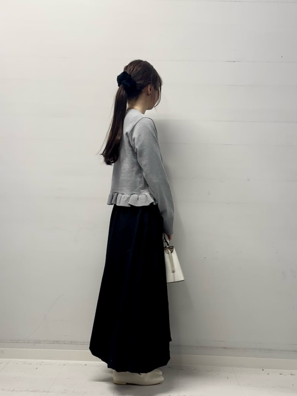 グレー系のニット/セーター、ブラック系のスカートを着用したレディースの冬コーディネートの2枚目の写真