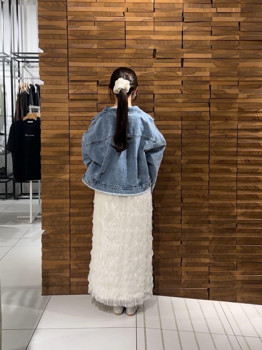 ホワイト系のスカート、ブルー系のデニムジャケット、ベージュ系のハンドバッグを着用したレディースの春コーディネートの3枚目の写真