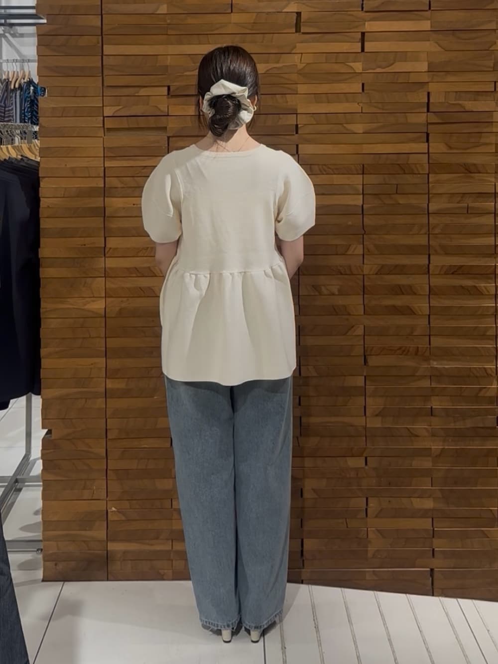 ブルー系のデニムパンツ、ホワイト系のハンドバッグを着用したレディースの春コーディネートの3枚目の写真