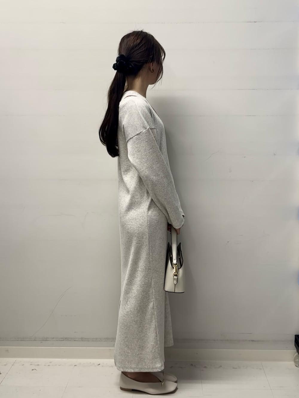 ベージュ系のワンピース、ホワイト系のその他シューズ、ホワイト系のショルダーバッグを着用したレディースの冬コーディネートの2枚目の写真