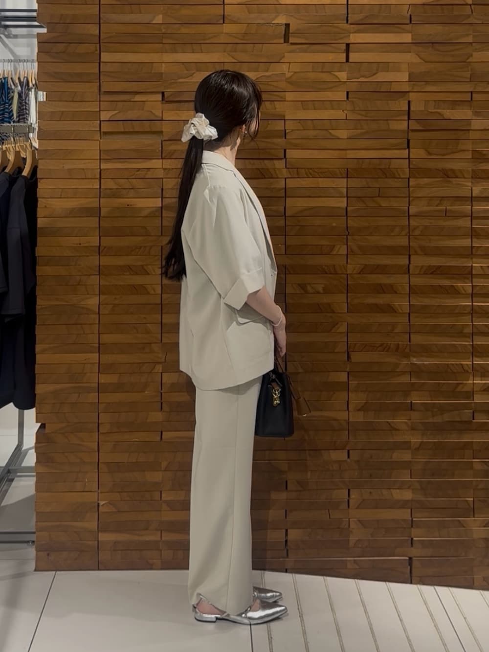 ベージュ系のその他アウター、ベージュ系のその他パンツ、ブラック系のハンドバッグを着用したレディースの春コーディネートの2枚目の写真