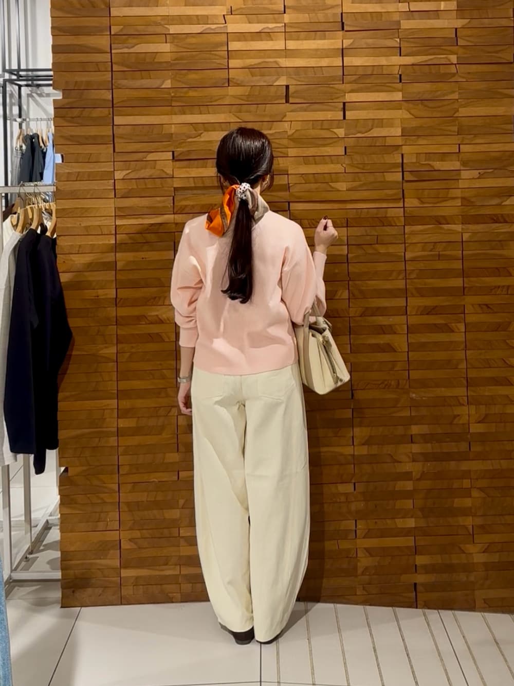 ピンク系のカーディガン/ボレロ、ホワイト系のその他パンツ、ホワイト系のハンドバッグを着用したレディースの秋コーディネートの3枚目の写真