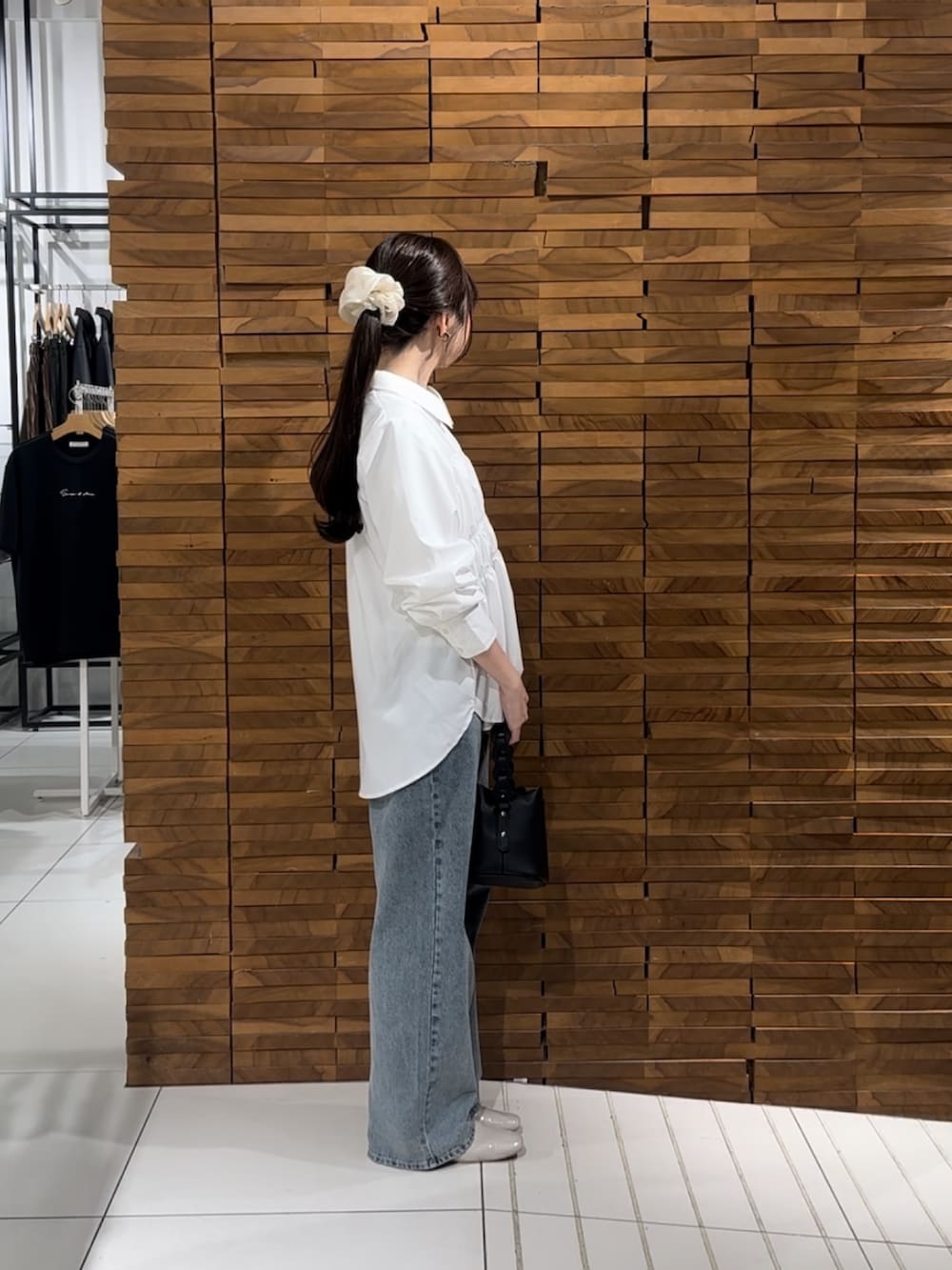 ホワイト系のシャツ/ブラウス、ブルー系のデニムパンツ、ブラック系のショルダーバッグを着用したレディースの春コーディネートの2枚目の写真