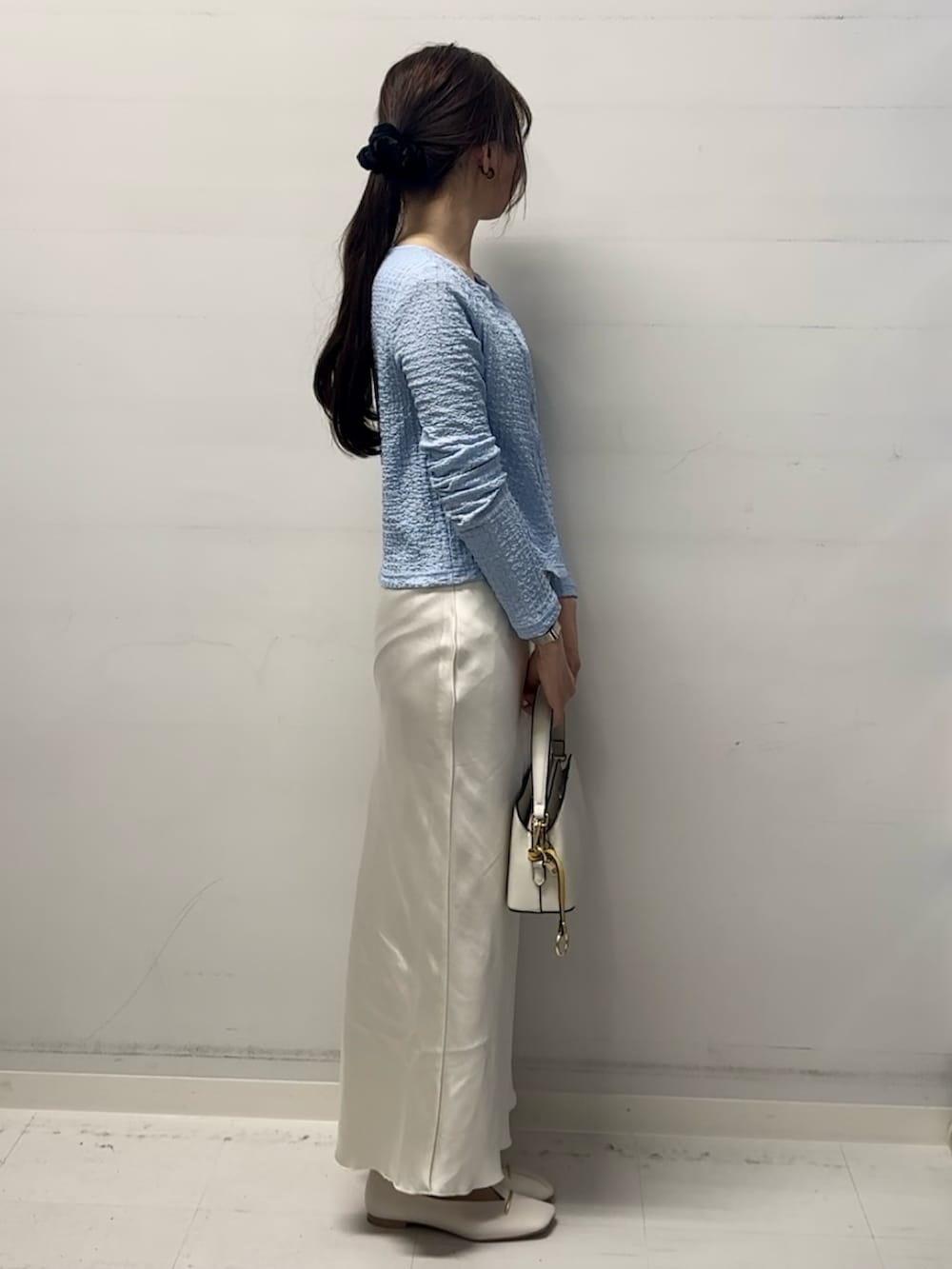 ブルー系のカーディガン/ボレロ、ホワイト系のスカート、ホワイト系のショルダーバッグを着用したレディースの冬コーディネートの2枚目の写真