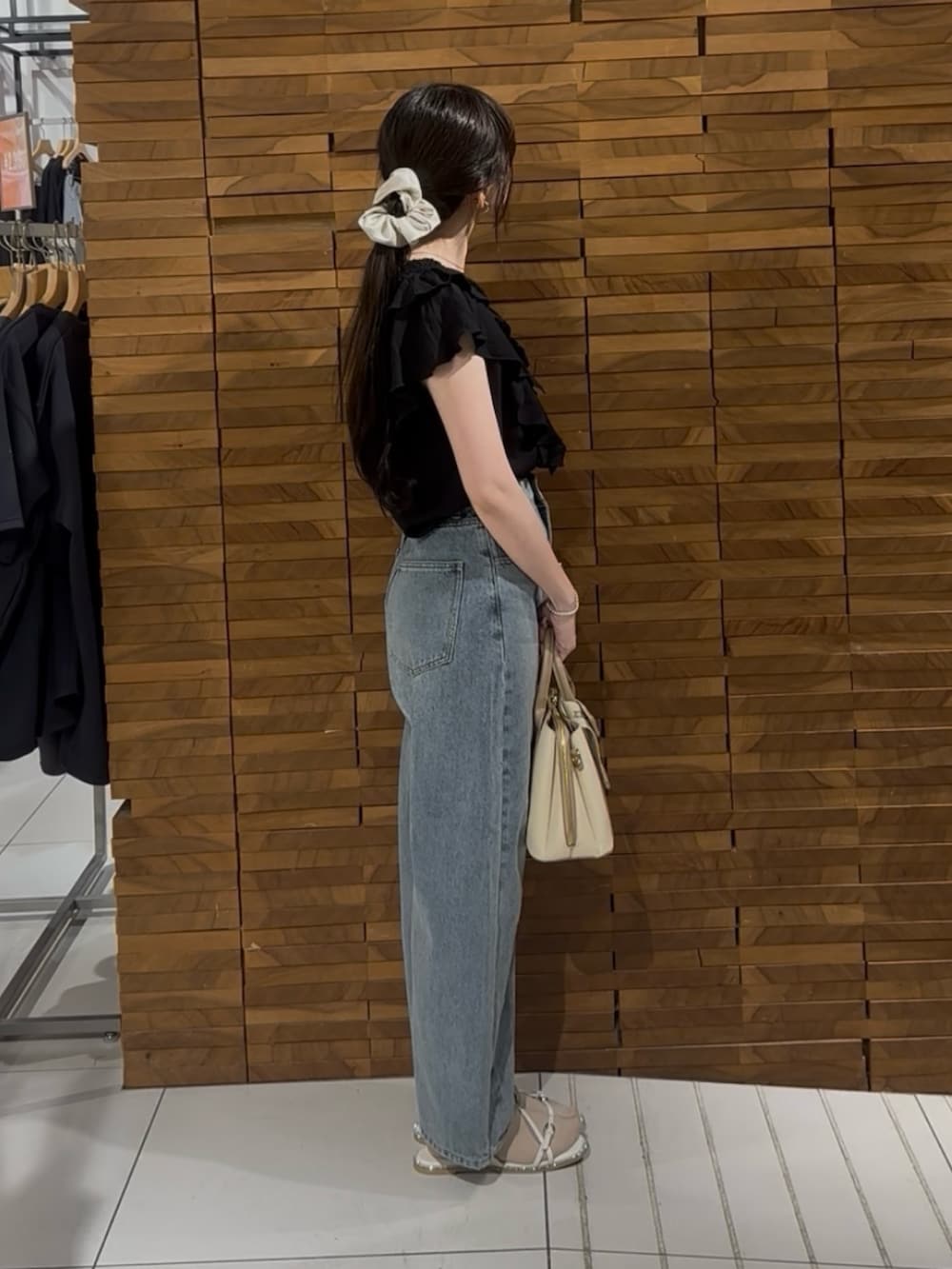 ブラック系のシャツ/ブラウス、ブルー系のデニムパンツ、ホワイト系のハンドバッグを着用したレディースの春コーディネートの2枚目の写真