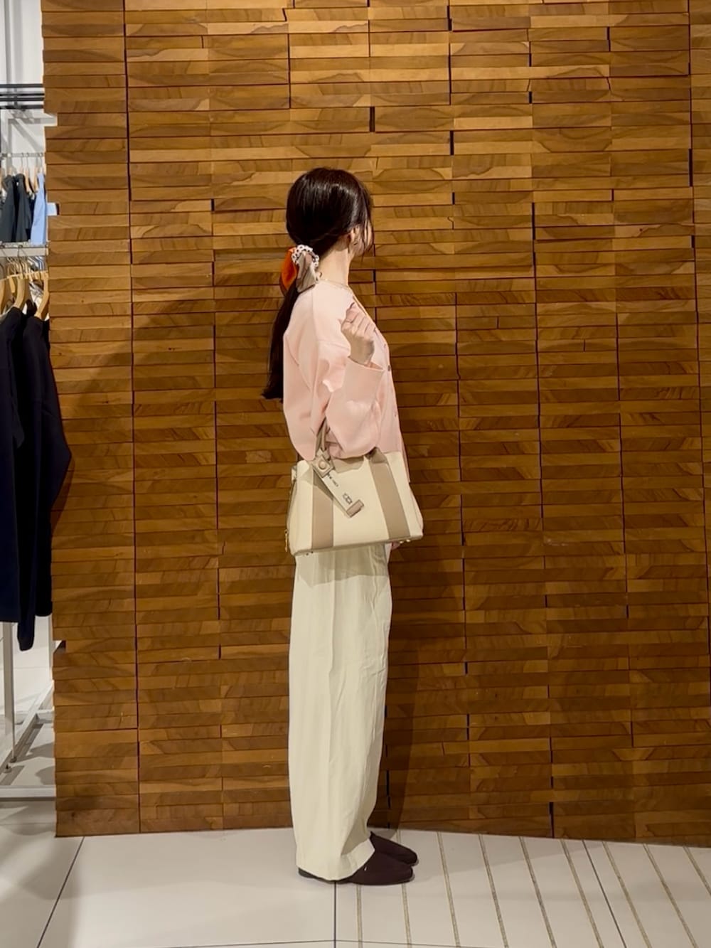 ピンク系のカーディガン/ボレロ、ホワイト系のその他パンツ、ホワイト系のハンドバッグを着用したレディースの秋コーディネートの2枚目の写真