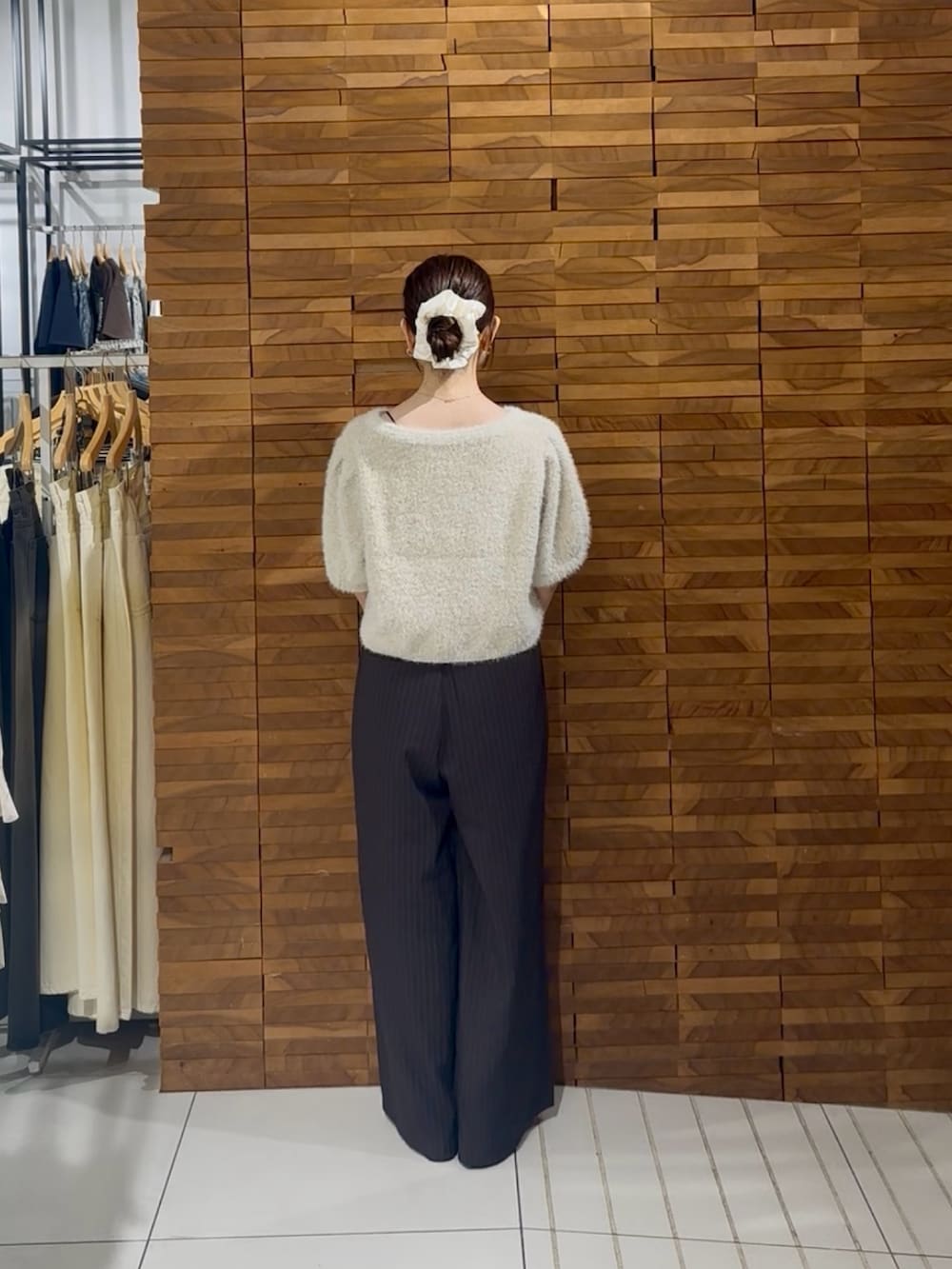 ホワイト系のニット/セーター、ブラウン系のその他パンツ、ゴールド系のハンドバッグを着用したレディースの秋コーディネートの3枚目の写真