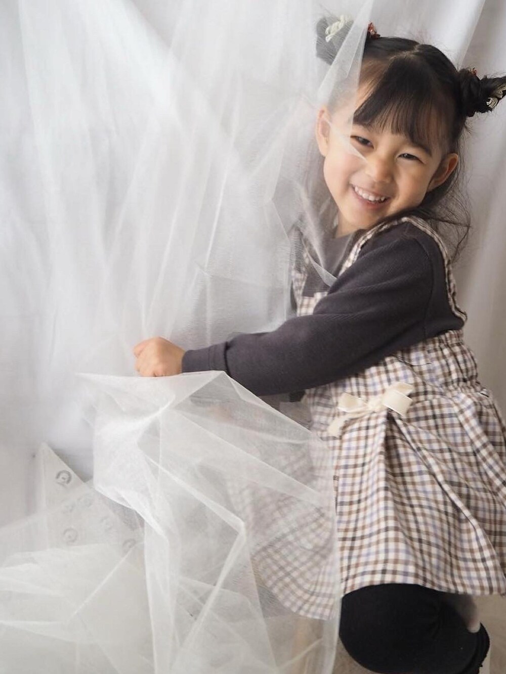 ベージュ系のTシャツ/カットソーを着用したキッズの冬コーディネートの2枚目の写真