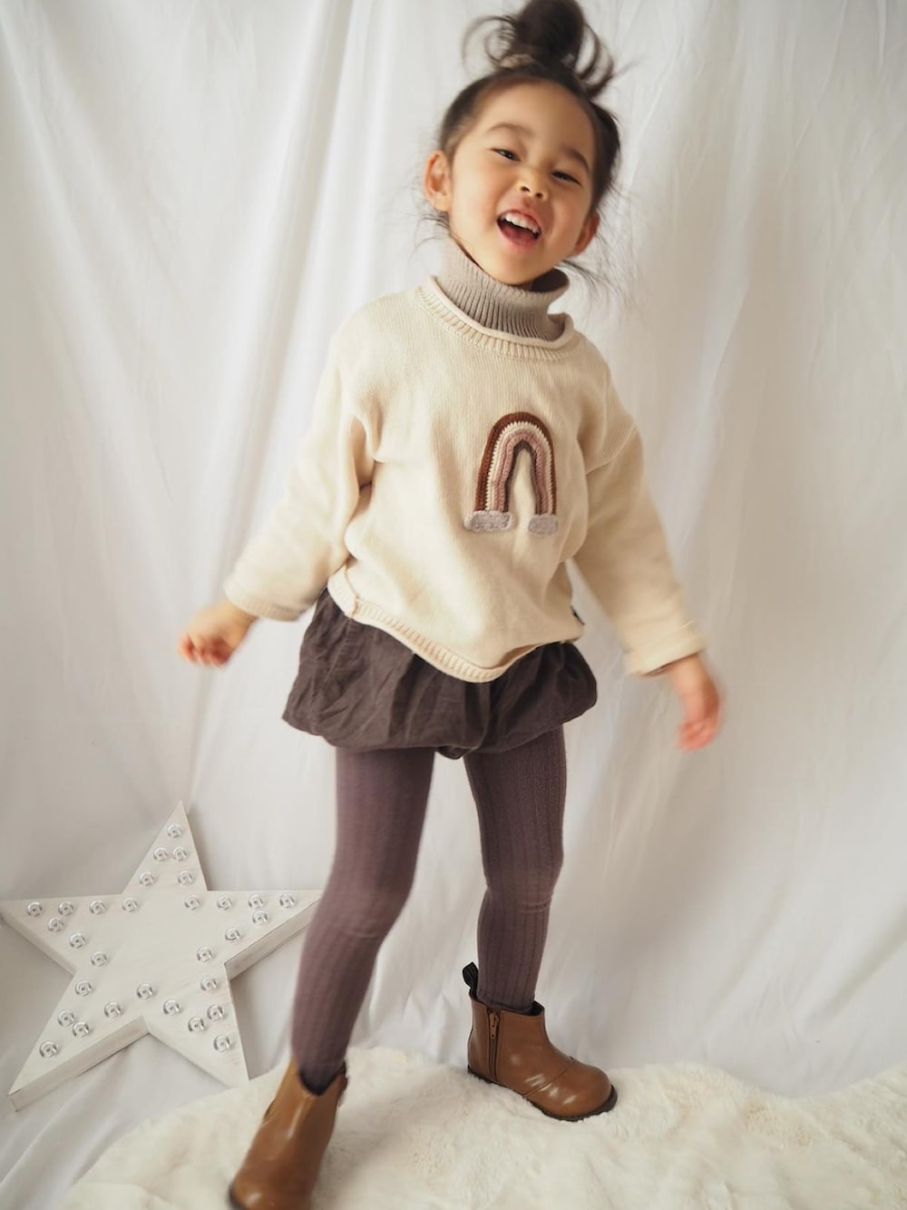 ブラウン系のブーツ、ベージュ系のニット/セーター、ブラウン系のタイツ/ストッキングを着用したレディースの冬コーディネートの3枚目の写真