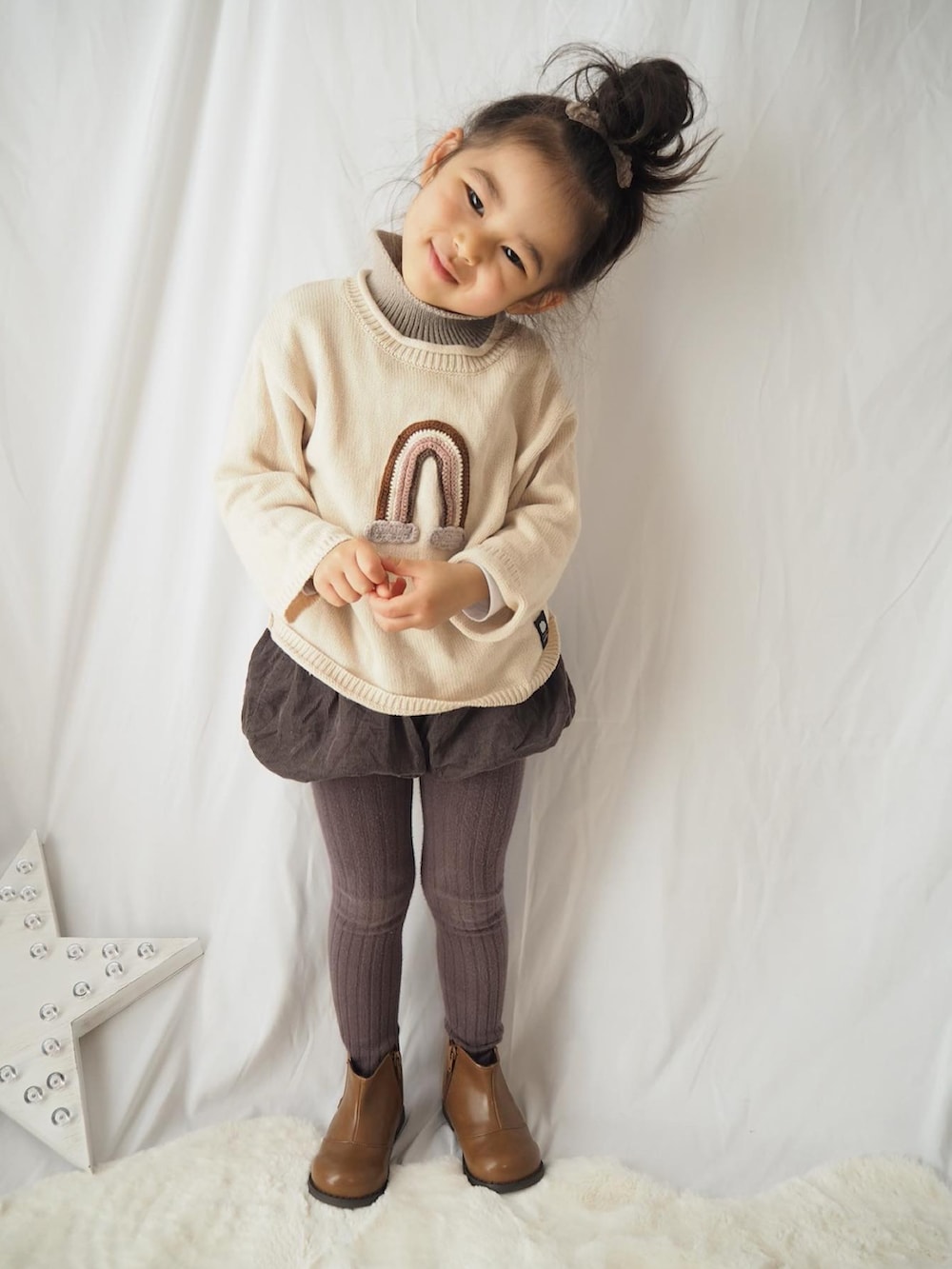 ブラウン系のブーツ、ベージュ系のニット/セーター、ブラウン系のタイツ/ストッキングを着用したレディースの冬コーディネートの2枚目の写真