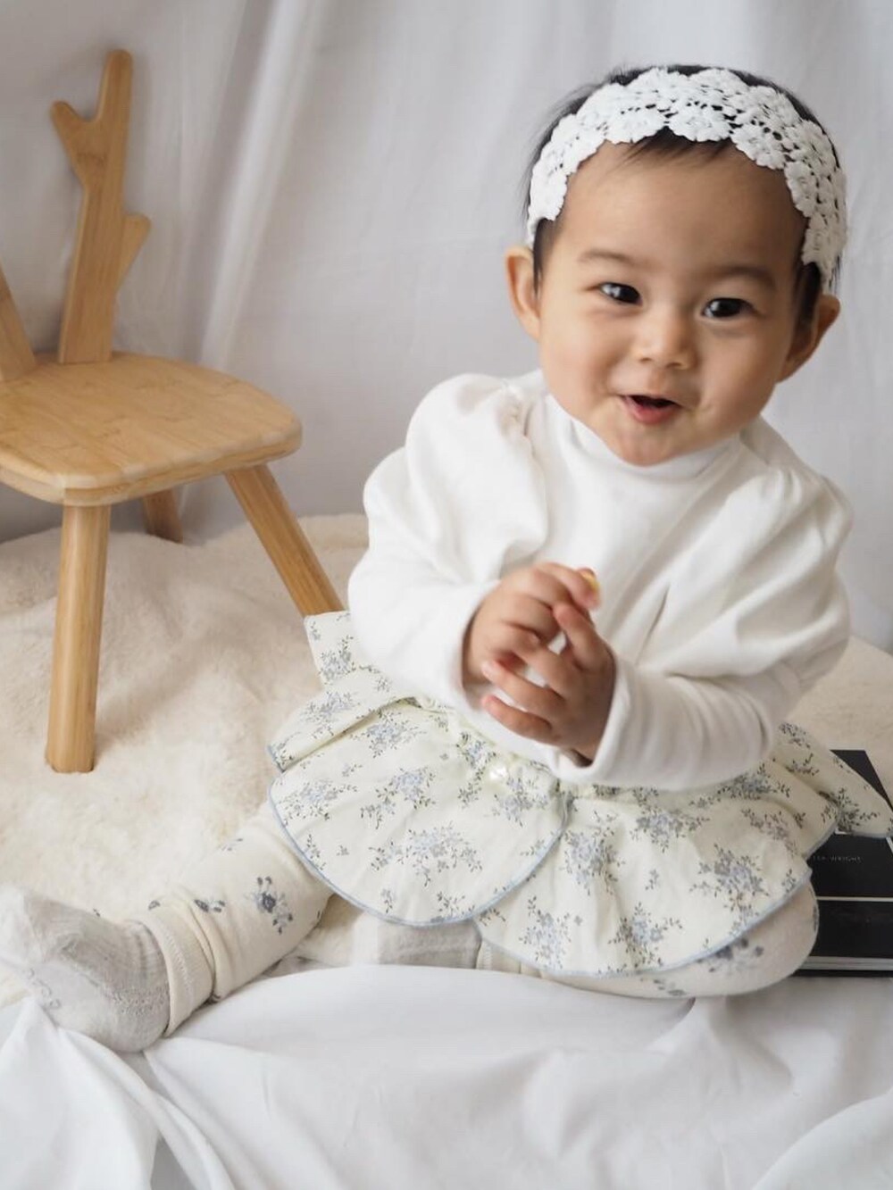 ホワイト系のスカート、ホワイト系のその他ベビーウェアを着用したキッズの冬コーディネートの2枚目の写真