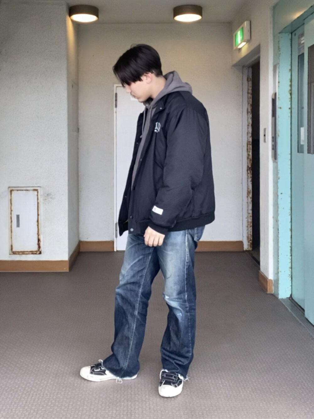 ブラック系のスニーカーを着用したメンズの冬コーディネートの2枚目の写真