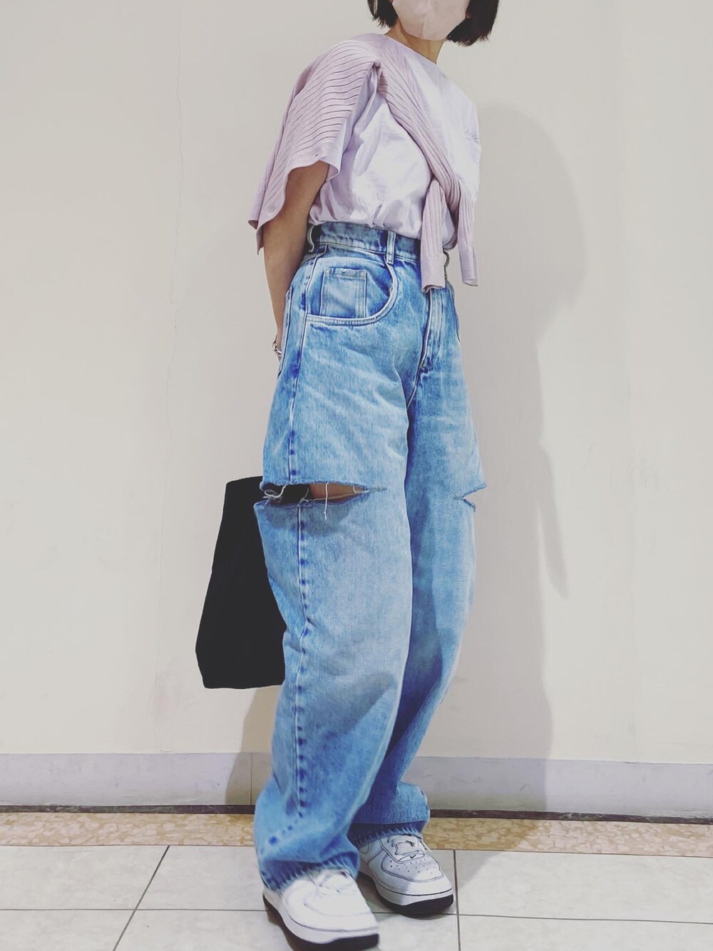 ピンク系のTシャツ/カットソー、ブルー系のデニムパンツ、ホワイト系のスニーカーを着用したレディースの春コーディネートの2枚目の写真