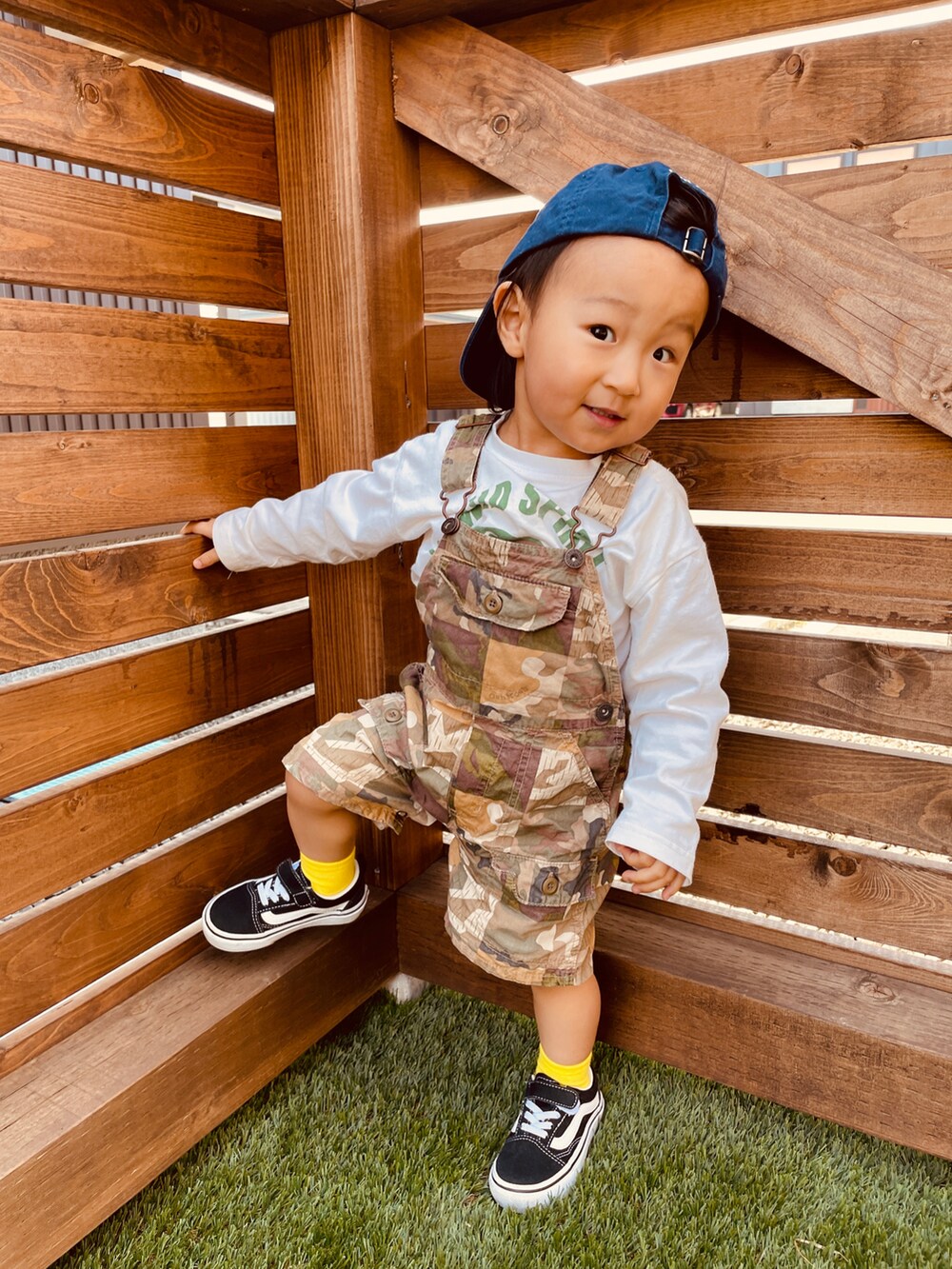 グリーン系のサロペット/オーバーオール、ホワイト系のTシャツ/カットソー、ブラック系のスニーカーを着用したキッズの春コーディネートの3枚目の写真