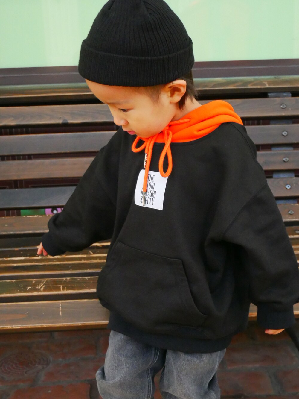 ブラック系のパーカー、グレー系のデニムパンツ、ブラック系のニットキャップ/ビーニーを着用したキッズの春コーディネートの4枚目の写真