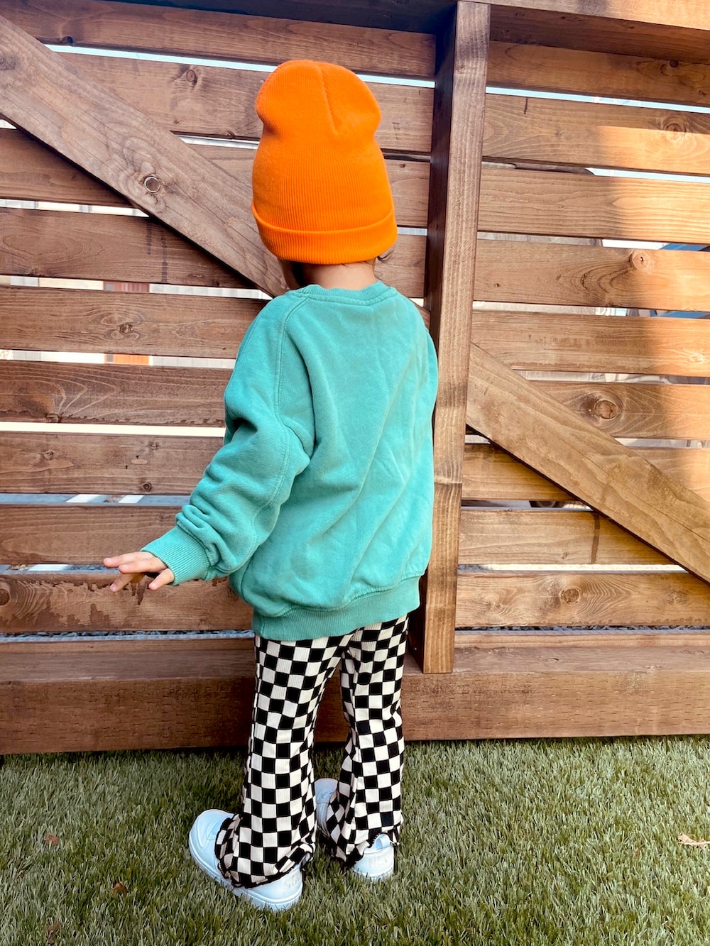 グリーン系のスウェット、ブラック系のその他パンツ、オレンジ系のニットキャップ/ビーニーを着用したキッズの春コーディネートの3枚目の写真