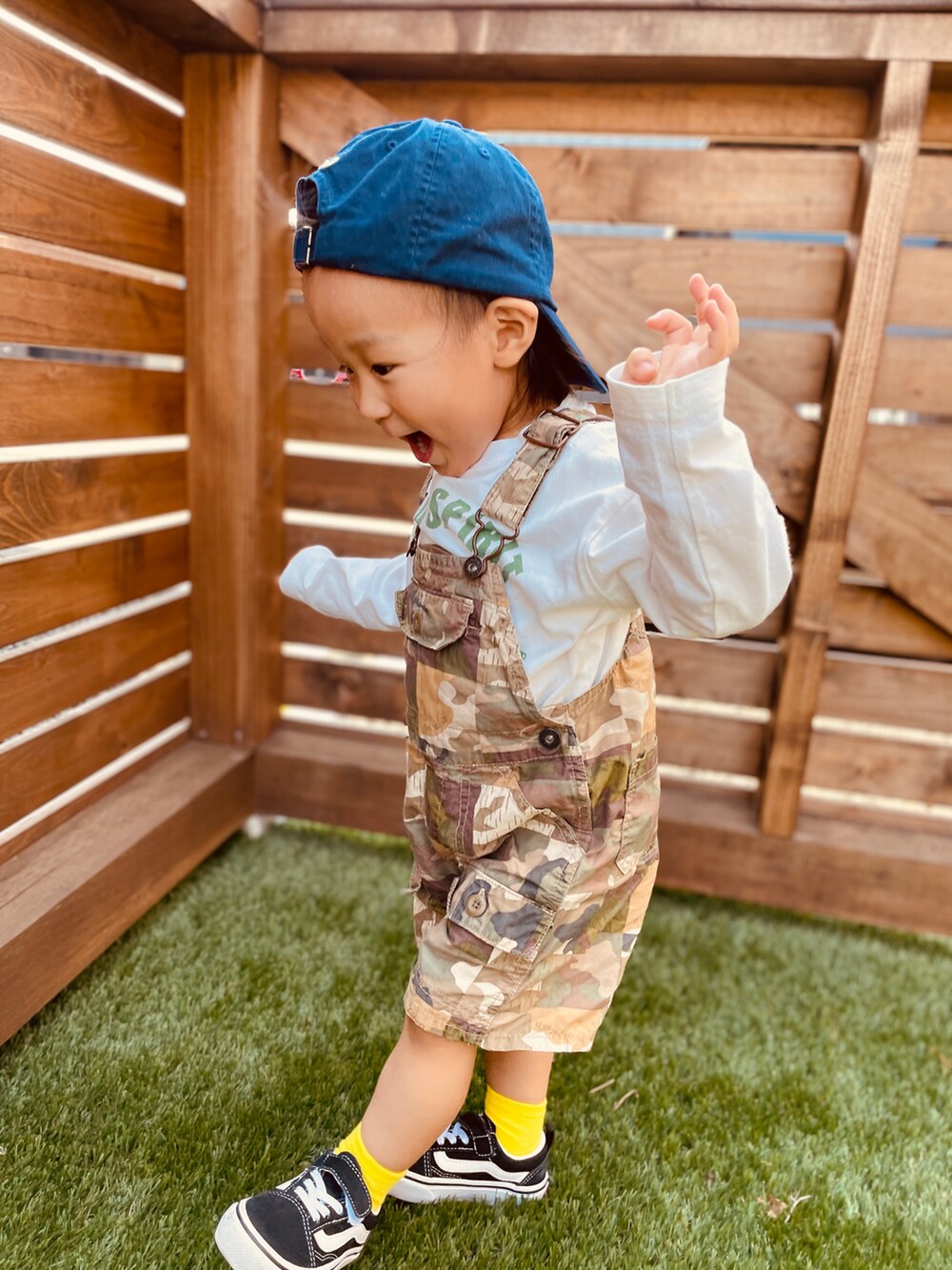 グリーン系のサロペット/オーバーオール、ホワイト系のTシャツ/カットソー、ブラック系のスニーカーを着用したキッズの春コーディネートの2枚目の写真