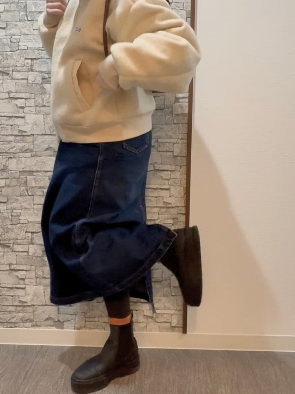 ホワイト系のブルゾン、その他のデニムスカート、ホワイト系のブーツを着用したレディースの冬コーディネートの2枚目の写真