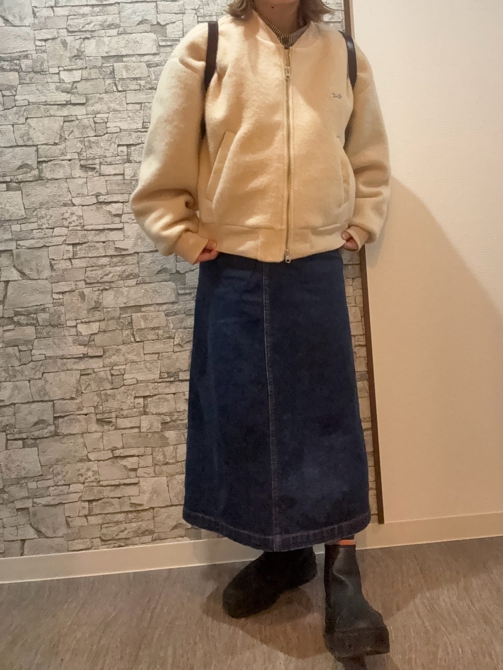 ホワイト系のブルゾン、その他のデニムスカート、ホワイト系のブーツを着用したレディースの冬コーディネートの3枚目の写真