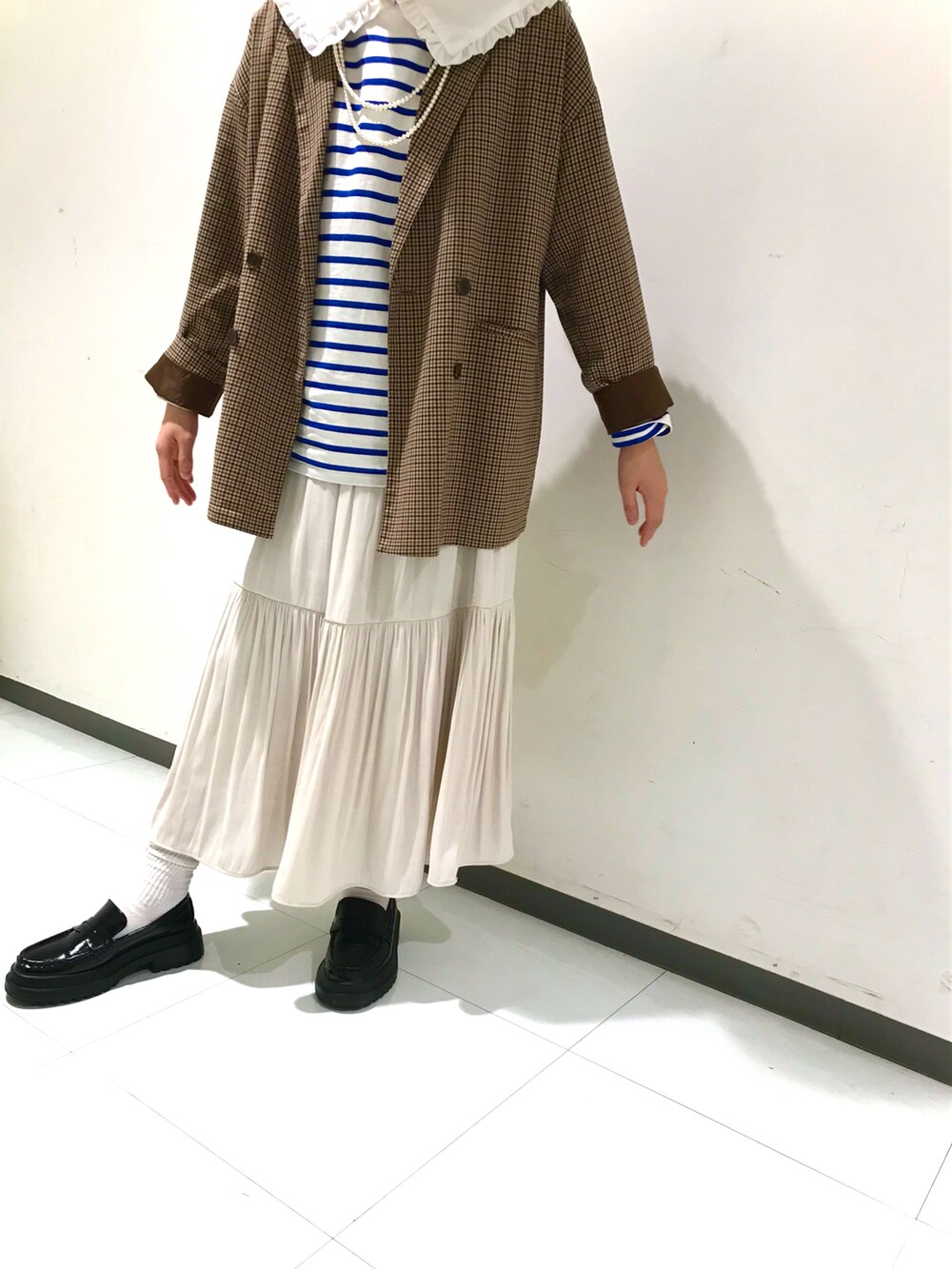 ブラウン系のジャケット/アウター、ブラック系のローファー、ホワイト系のスカートを着用したキッズの春コーディネートの4枚目の写真