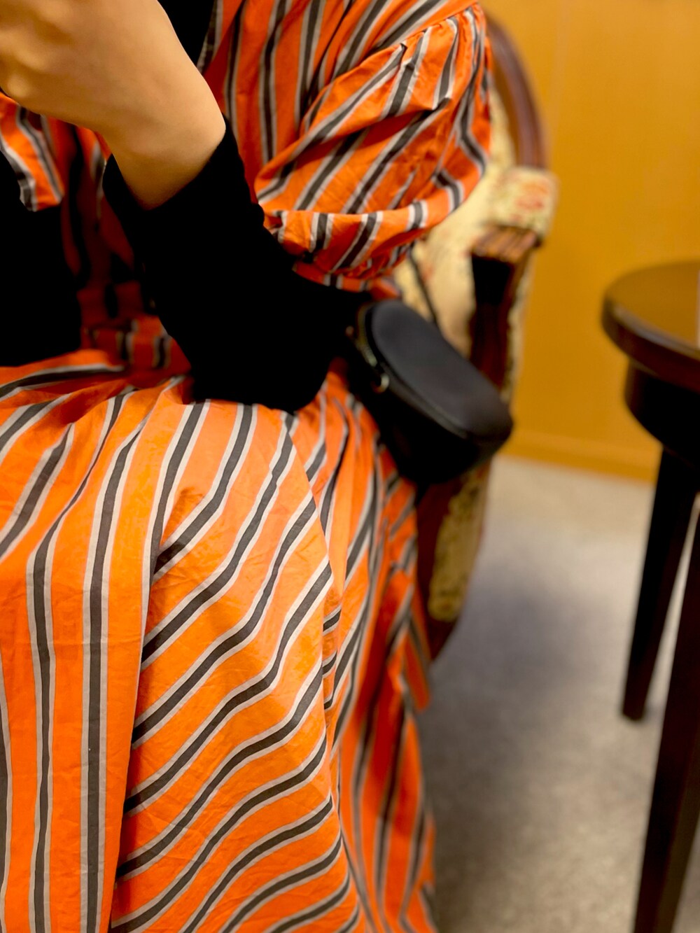 オレンジ系のワンピース、グリーン系のキャップを着用したキッズの春コーディネートの2枚目の写真