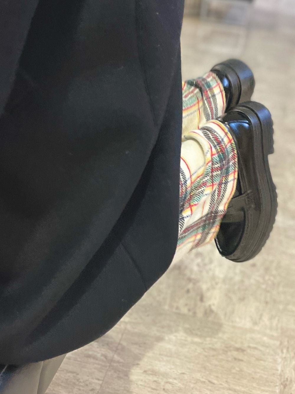 ホワイト系のその他パンツ、ブラック系のステンカラーコートを着用したキッズの冬コーディネートの2枚目の写真