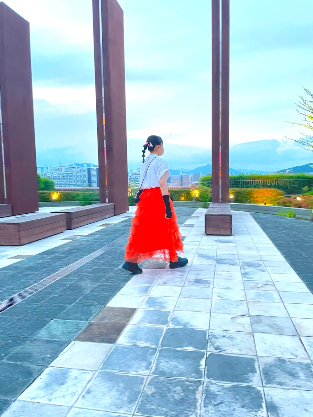 オレンジ系のスカート、ブラック系のアームカバーを着用したキッズの夏コーディネートの4枚目の写真