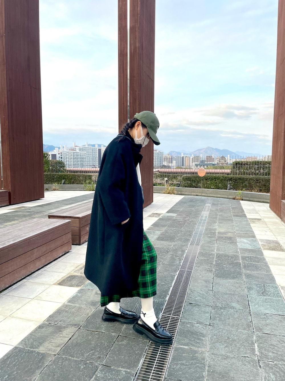 ブラック系のステンカラーコート、グリーン系のキャップを着用したキッズの冬コーディネートの3枚目の写真