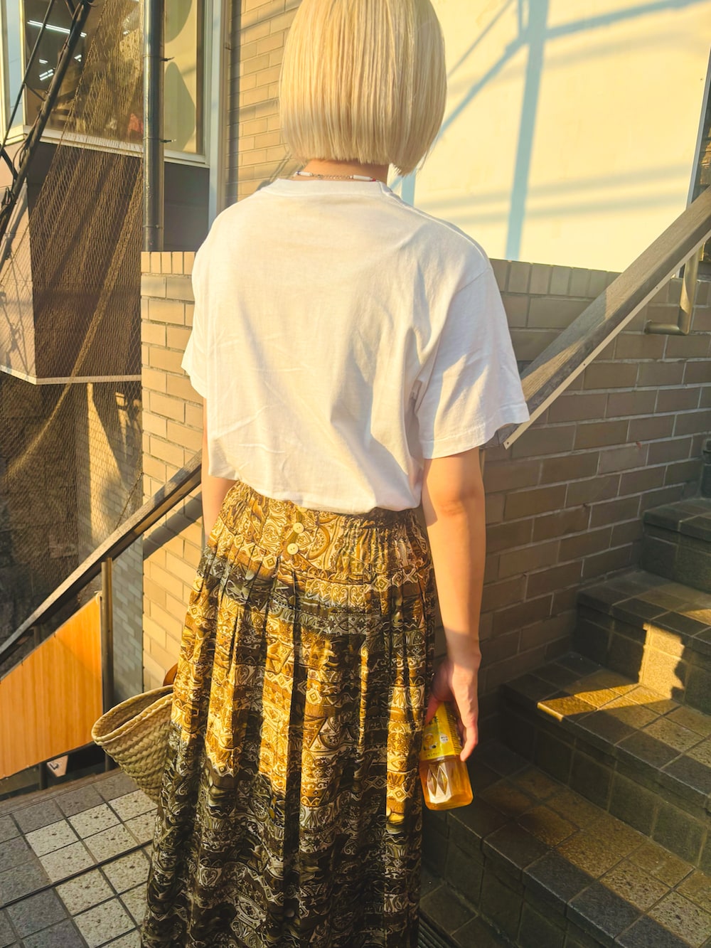 ブラウン系のスカート、ホワイト系のTシャツ/カットソーを着用したキッズの夏コーディネートの2枚目の写真