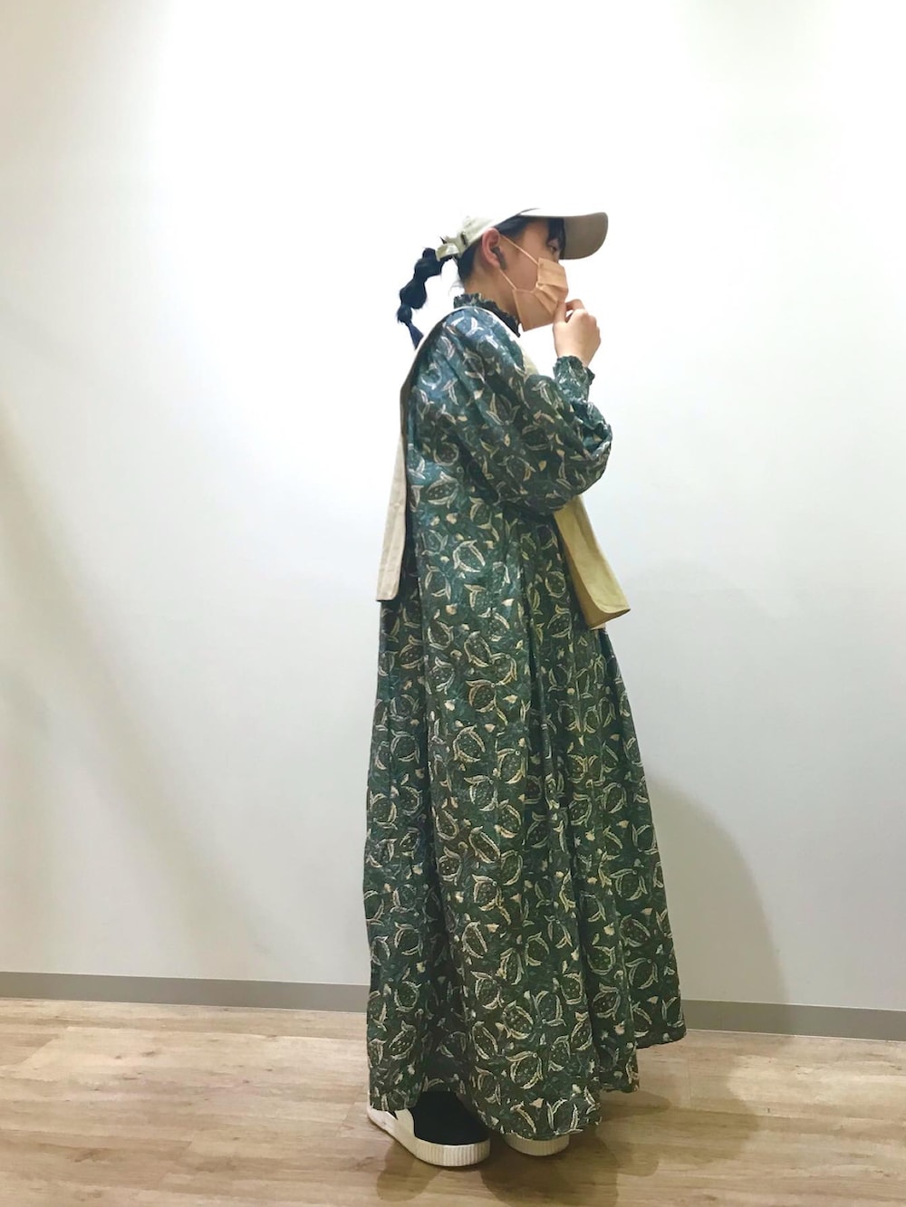 グリーン系のワンピース、ブラック系のスニーカーを着用したキッズの春コーディネートの3枚目の写真