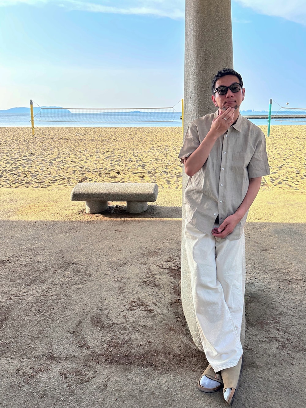 ブラック系のTシャツ/カットソー、ホワイト系のその他パンツ、ベージュ系のサンダルを着用したメンズの春コーディネートの2枚目の写真