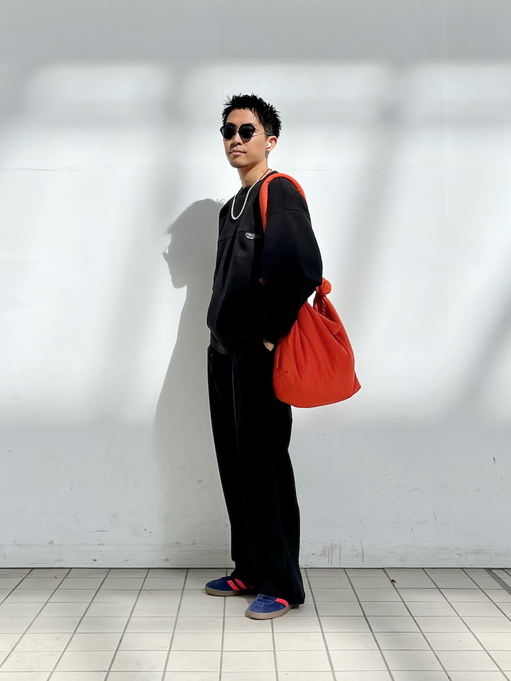 ブラック系のスウェット、ブラック系のその他パンツ、ブルー系のスニーカーを着用したメンズの秋コーディネートの2枚目の写真