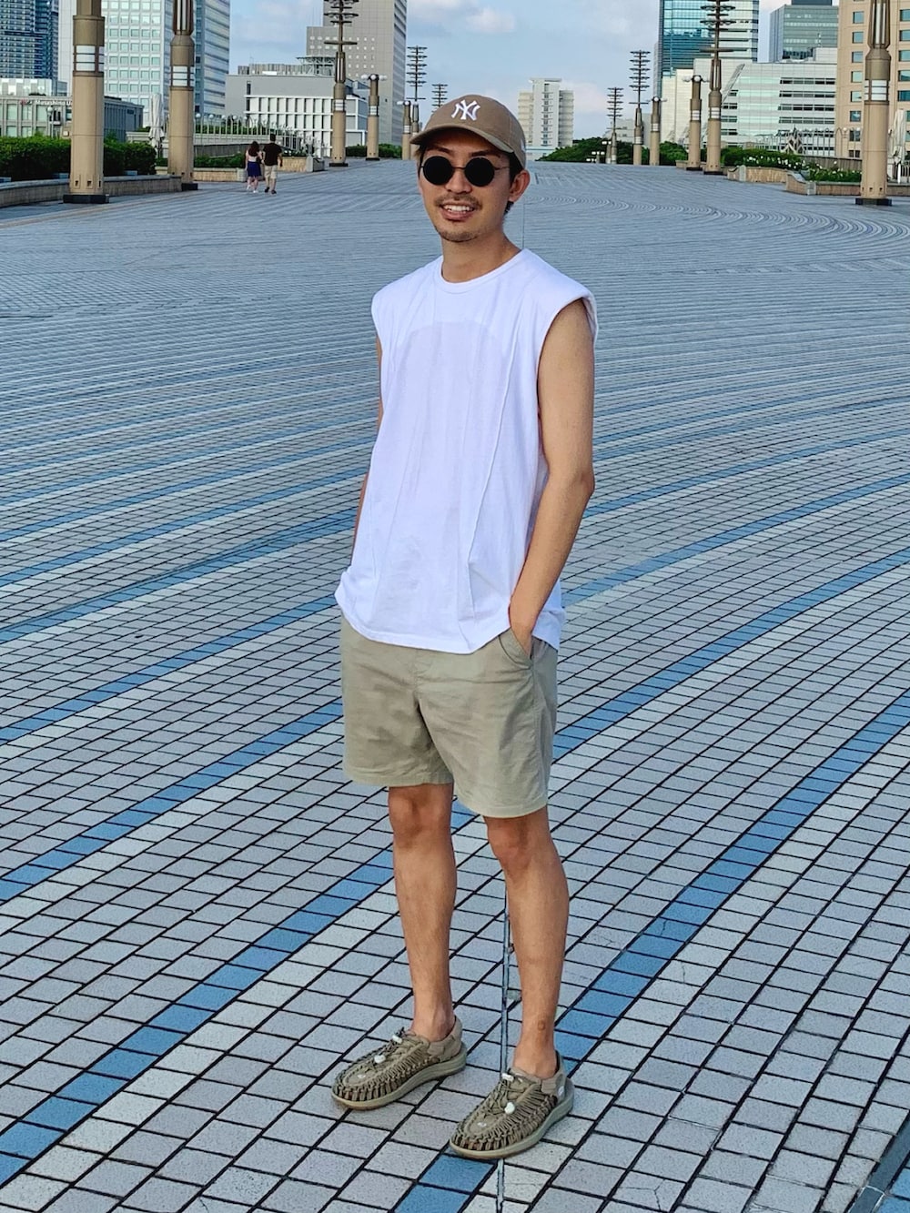 ホワイト系のTシャツ/カットソー、ベージュ系のパンツ、ブラウン系のサンダルを着用したメンズの秋コーディネートの2枚目の写真