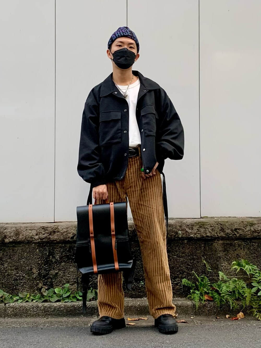 ブラック系のブルゾン、ホワイト系のTシャツ/カットソー、ブラウン系のパンツを着用したメンズの秋コーディネートの2枚目の写真