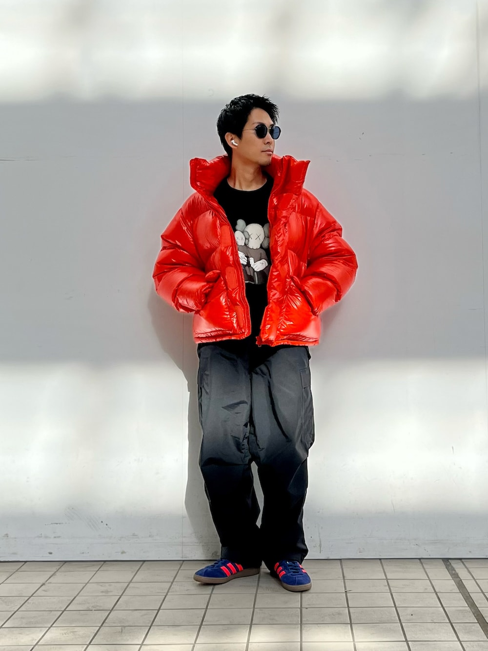 オレンジ系のダウンジャケット/コート、ブラック系のスウェット、ブラック系のカーゴパンツを着用したメンズの冬コーディネートの2枚目の写真