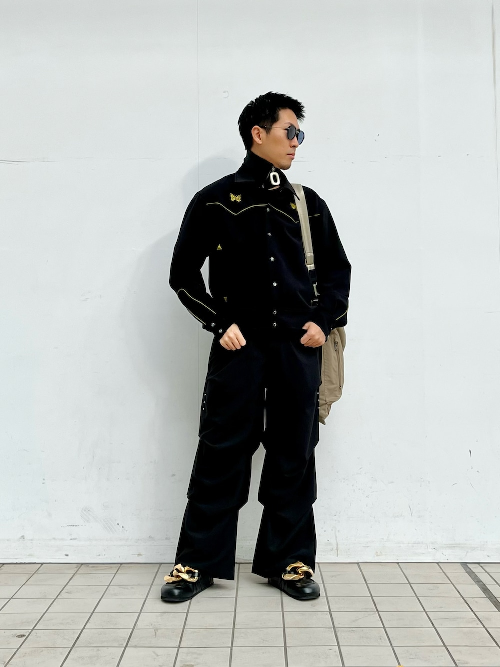 ブラック系のその他アウター、ブラック系のカーゴパンツ、ブラック系のシューズを着用したメンズの冬コーディネートの2枚目の写真