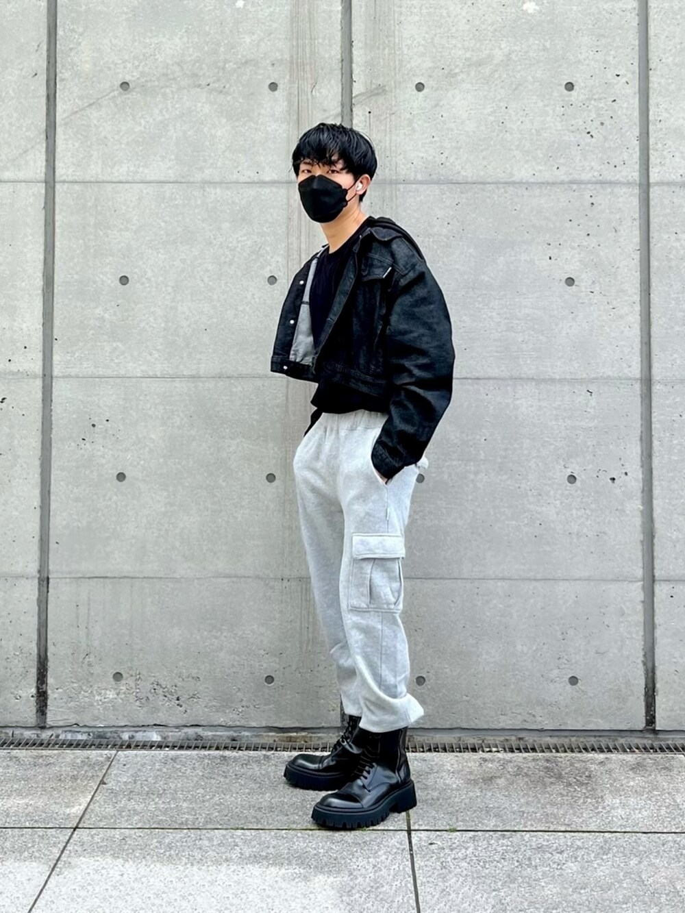 ブラック系のデニムジャケット、グレー系のカーゴパンツ、ブラック系のブーツを着用したメンズの春コーディネートの3枚目の写真