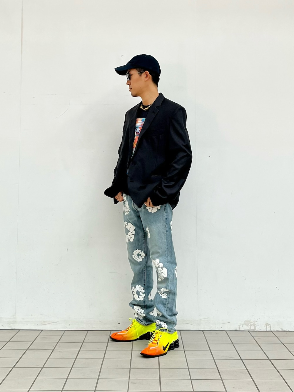 ブラック系のTシャツ/カットソー、ブルー系のデニムパンツ、イエロー系のスニーカーを着用したメンズの秋コーディネートの2枚目の写真