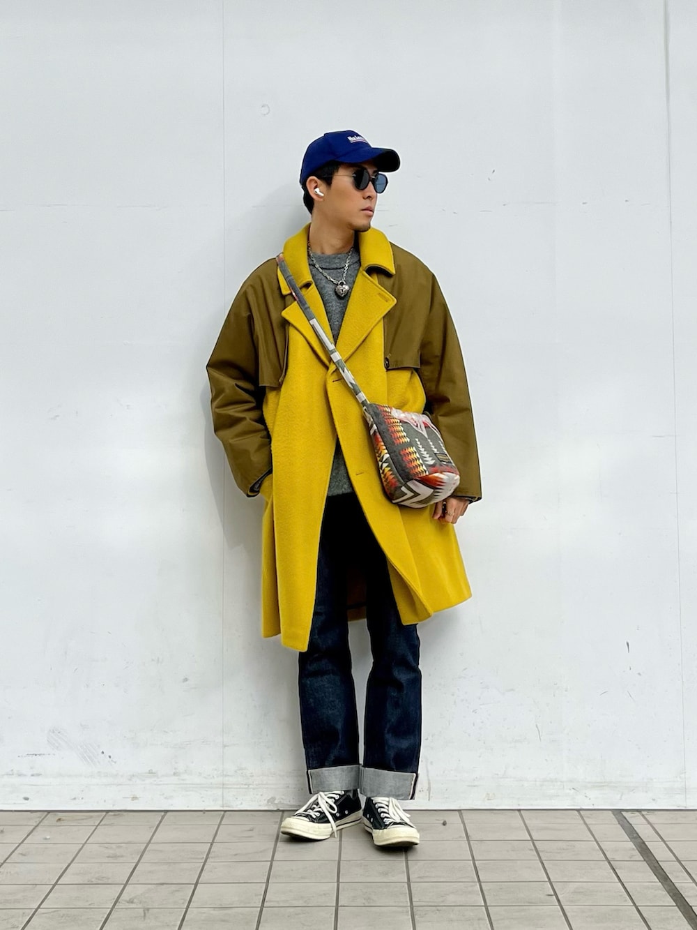 イエロー系のジャケット/アウター、グレー系のニット/セーター、ブルー系のデニムパンツを着用したメンズの冬コーディネートの2枚目の写真