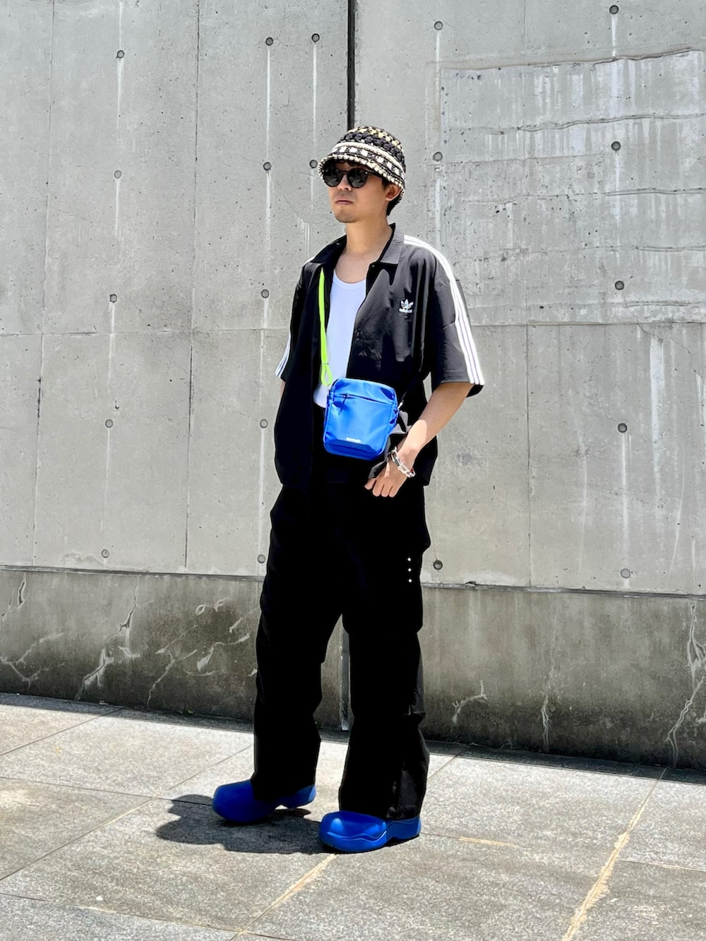 ブラック系のシャツ/ブラウス、ブラック系のカーゴパンツ、ブルー系のブーツを着用したメンズの夏コーディネートの2枚目の写真