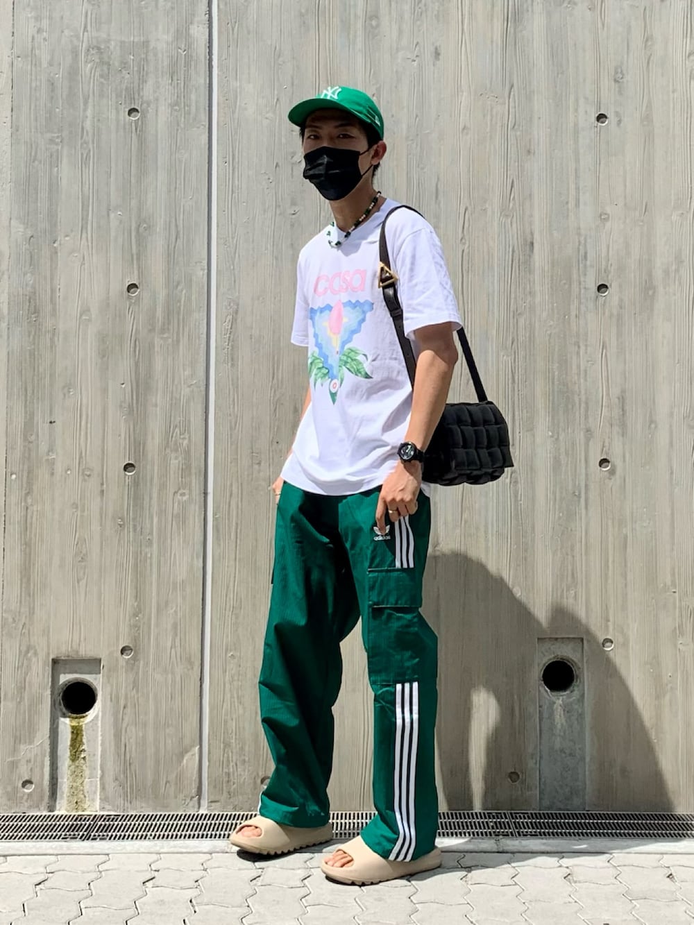 ホワイト系のTシャツ/カットソー、グリーン系のカーゴパンツ、ベージュ系のサンダルを着用したメンズの夏コーディネートの2枚目の写真