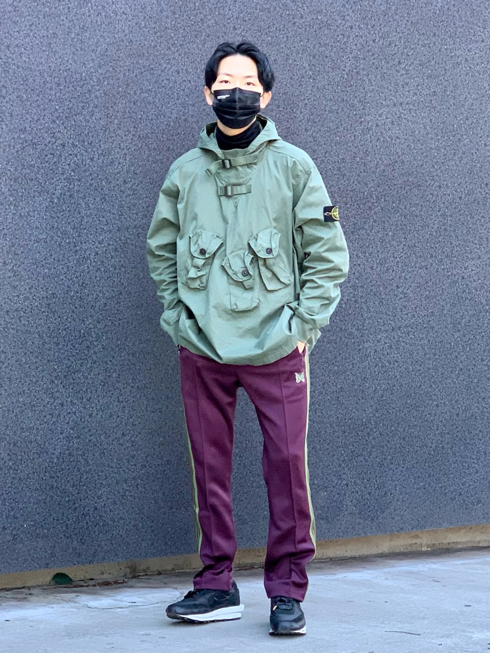 グリーン系のトップス、ブラック系のTシャツ/カットソー、パープル系のパンツを着用したメンズの冬コーディネートの2枚目の写真