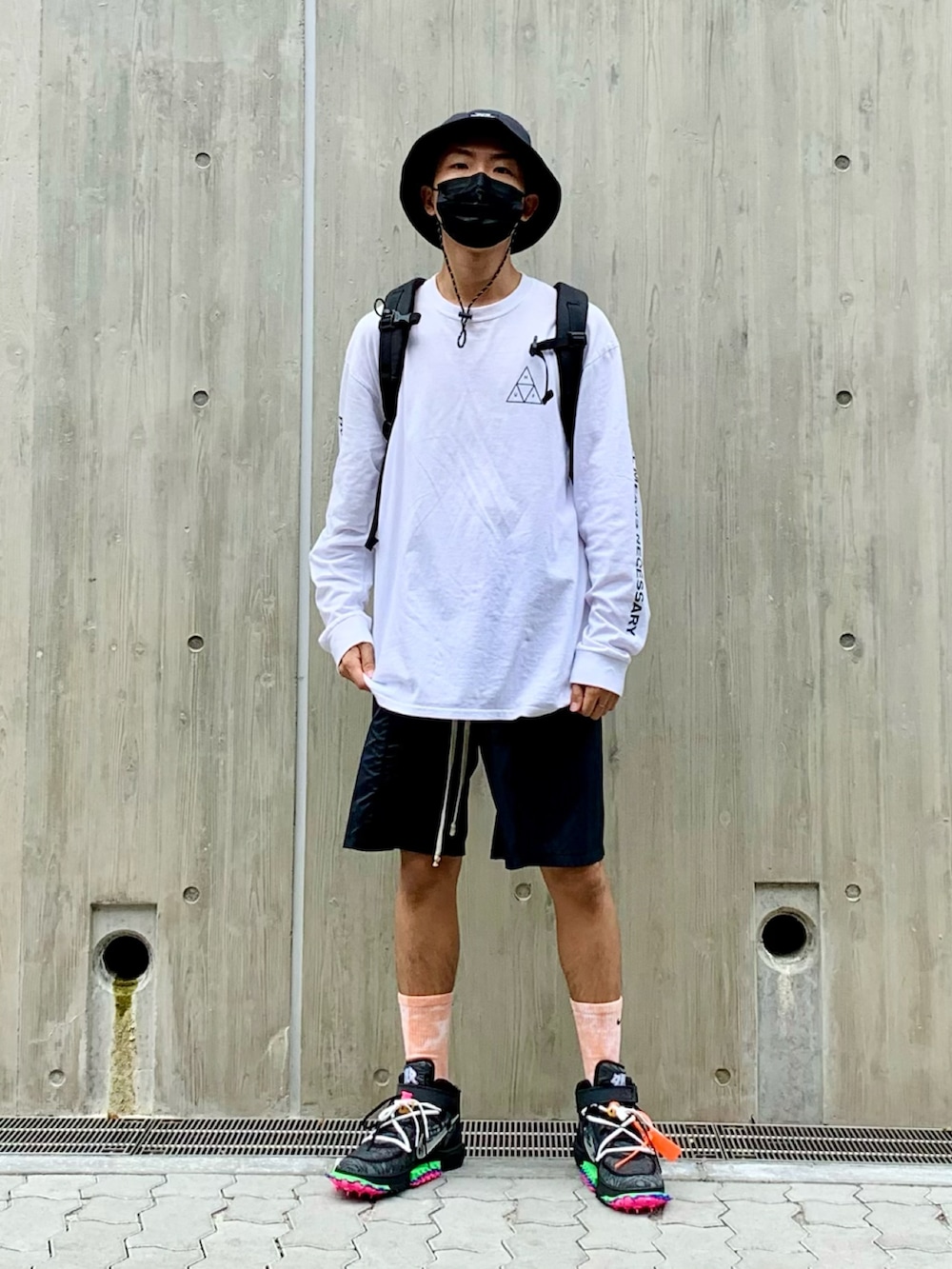 ホワイト系のTシャツ/カットソー、ブラック系のパンツ、ブラック系のスニーカーを着用したメンズの夏コーディネートの2枚目の写真