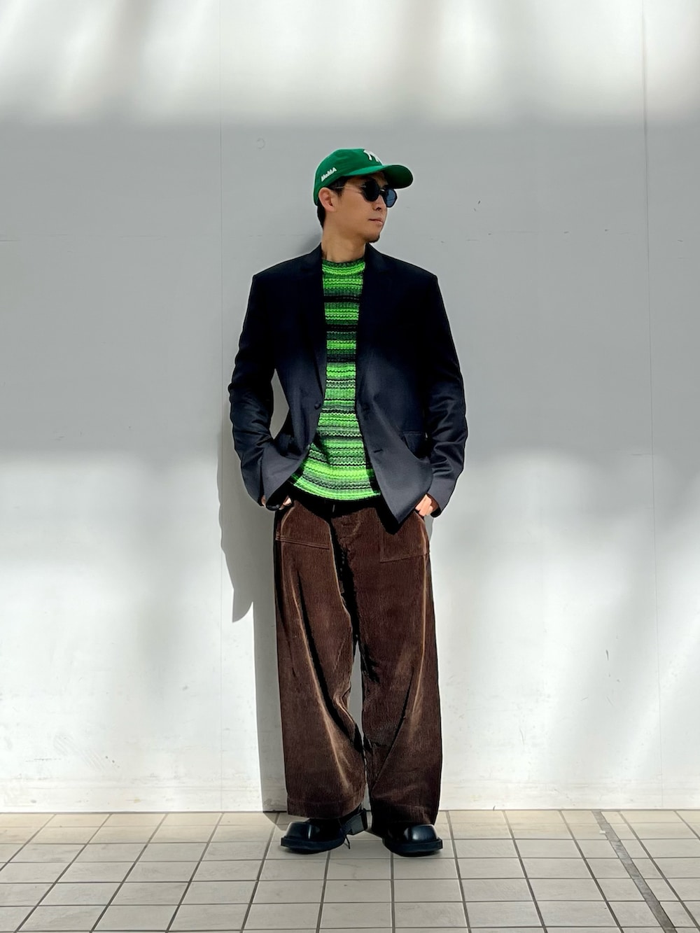 グリーン系のニット/セーター、ブラウン系のその他パンツ、グリーン系のキャップを着用したメンズの冬コーディネートの2枚目の写真