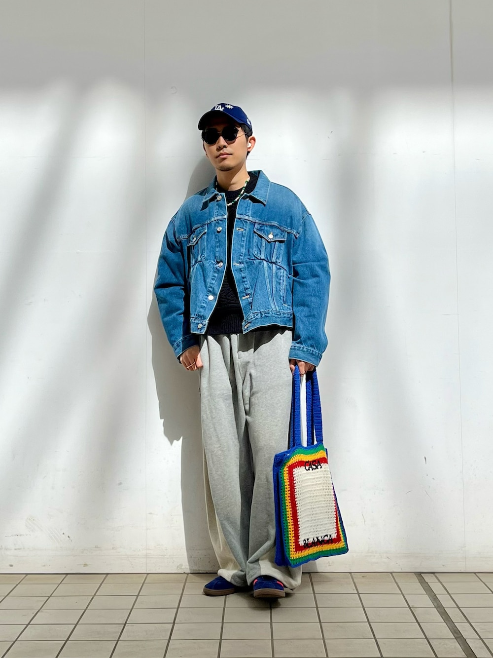 グレー系のスウェットパンツ、その他のトートバッグ、ブルー系のスニーカーを着用したメンズの春コーディネートの2枚目の写真