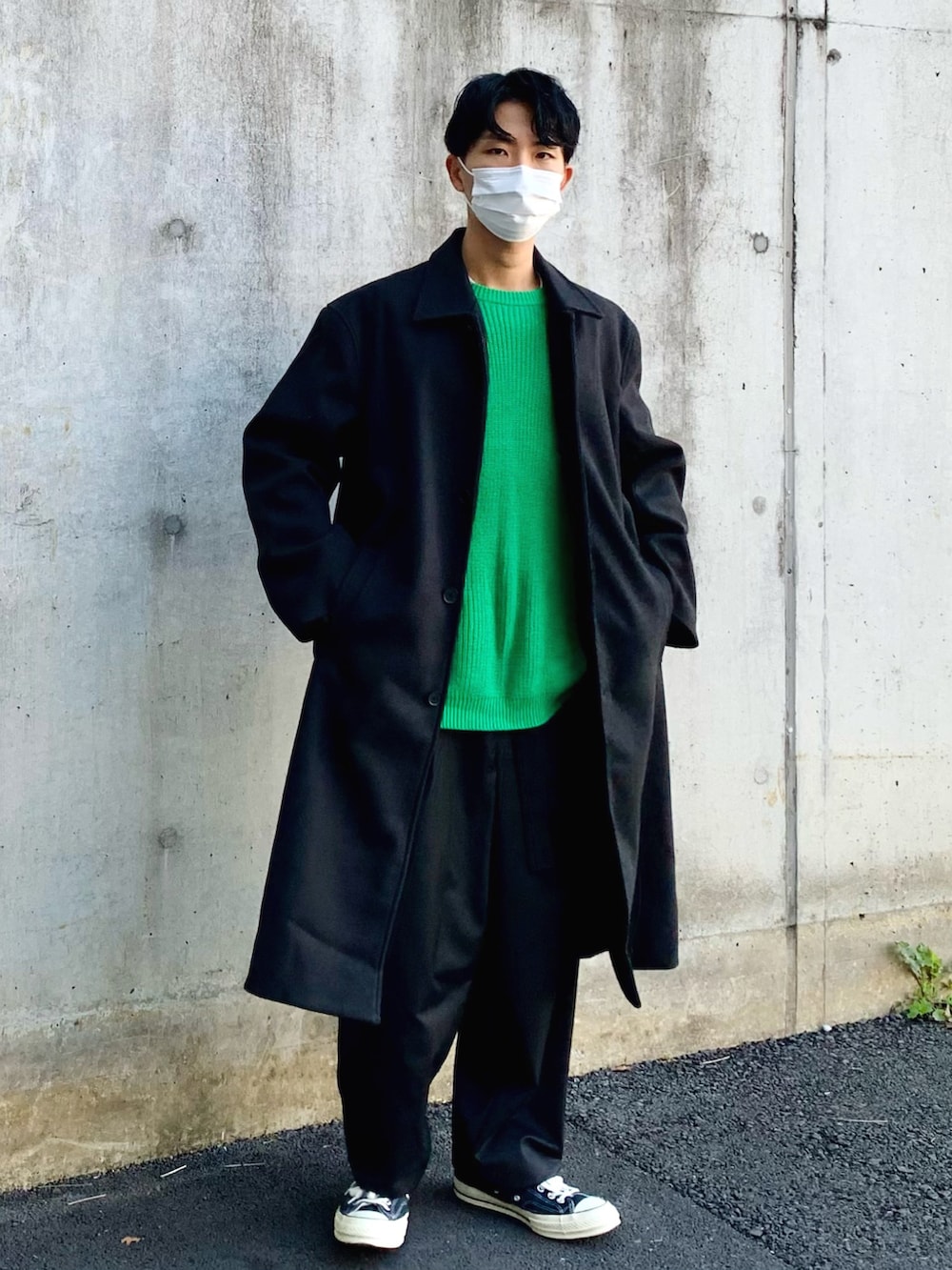 ブラック系のステンカラーコート、グリーン系のニット/セーター、ブラック系のその他パンツを着用したメンズの冬コーディネートの2枚目の写真