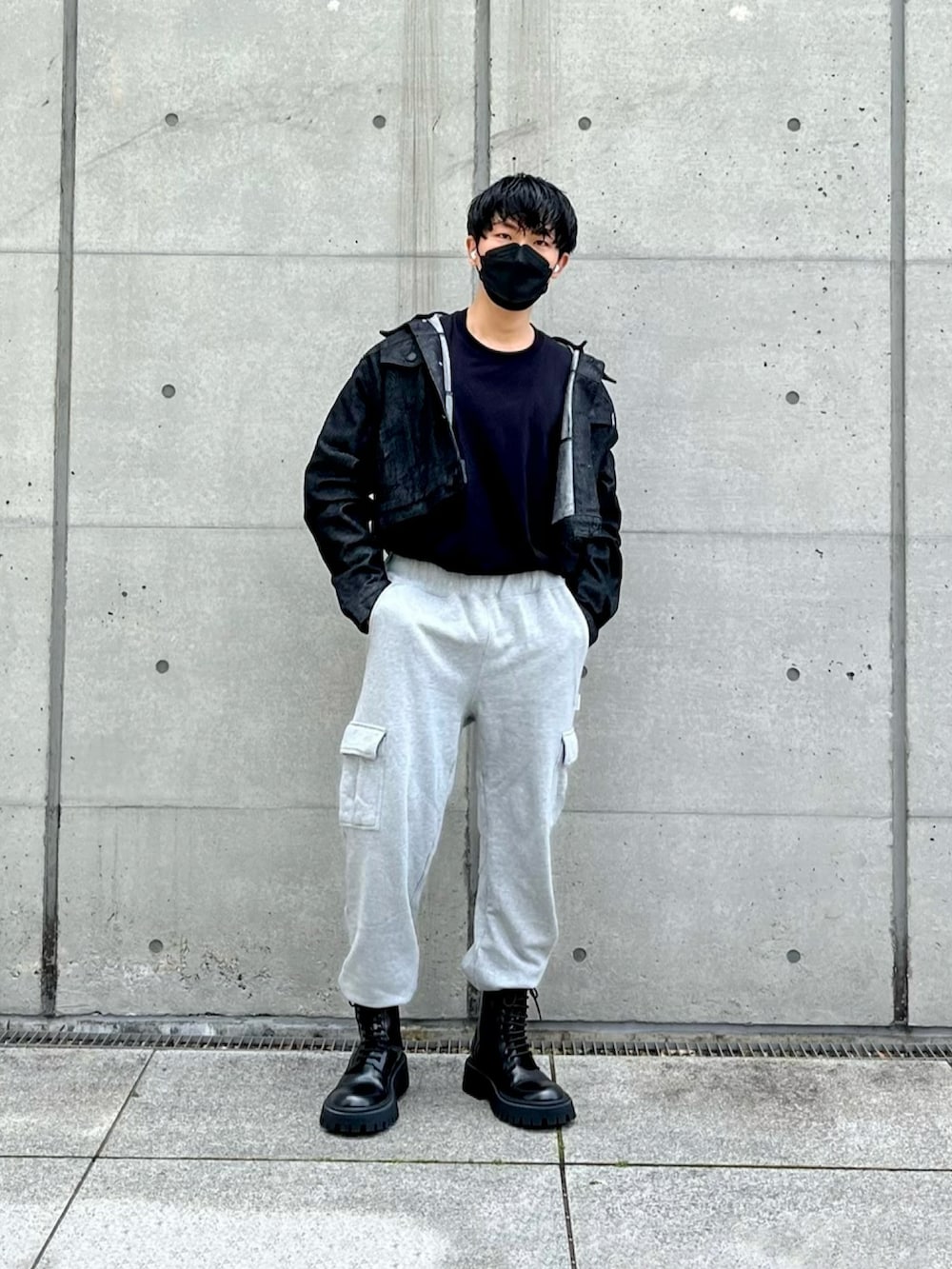 ブラック系のデニムジャケット、グレー系のカーゴパンツ、ブラック系のブーツを着用したメンズの春コーディネートの2枚目の写真